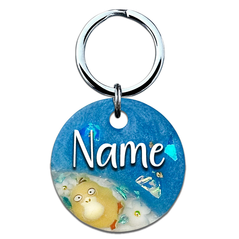 A picture of Schnapp sie dir alle, denn diese Marke ist ein guter Fang! Ein stylisches Split-Design aus glänzendem blauen Perlpigment, einem klaren Bereich mit einer kleinen Figur, Blumen und funkelnden Highlights aus goldenen Glitzersteinen sowie Aurora Flakes.