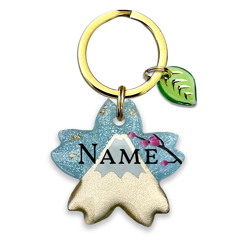 A picture of Ein kleines Stück Japan für dich und dein Haustier! Diese elegante Tiermarke ist inspiriert von Japans berühmten Berg Fuji-san. Die Marke kommt in einer Kirschblüten-Form und ist gestaltet mit filigranen Details. Der goldig glänzende Fuji steht vor hellblauem Perlpigment und wird abgerundet mit Pflaumenblüten sowie goldenen Glitzersteinen.